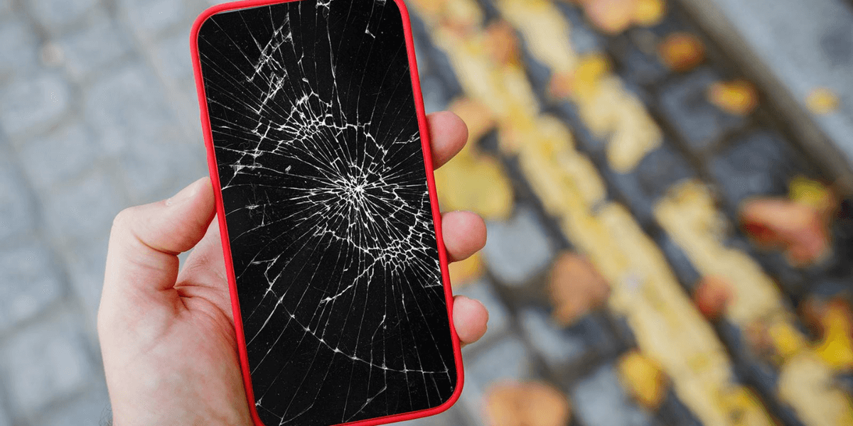 A picture phone whose screen is broken with a red back cover.