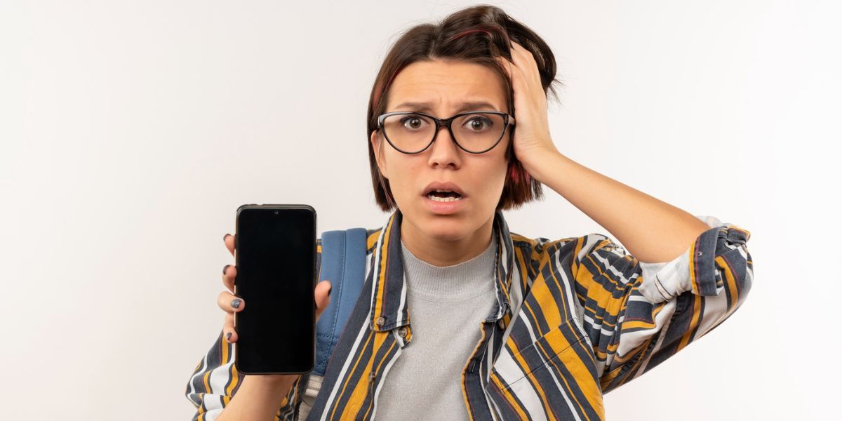 A woman looks distressed while holding a blank smartphone, possibly facing a screen issue or malfunction