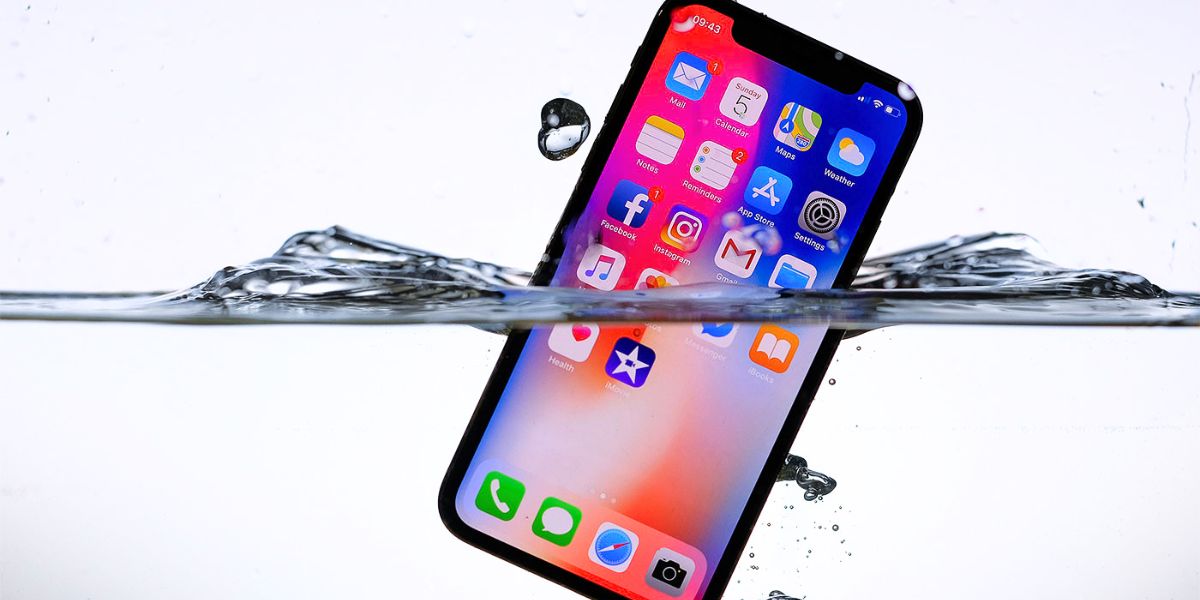 An iPhone is shown partially submerged in clear water with the screen still on.