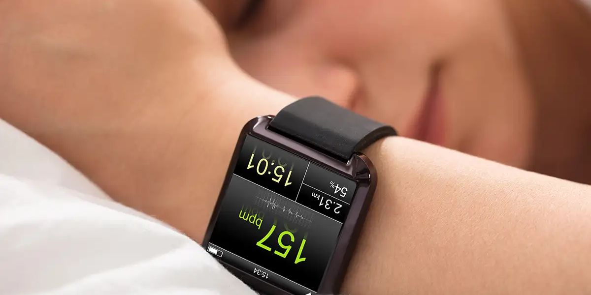 Close-up of a smartwatch worn on a wrist, displaying heart rate (157 bpm) and other fitness metrics