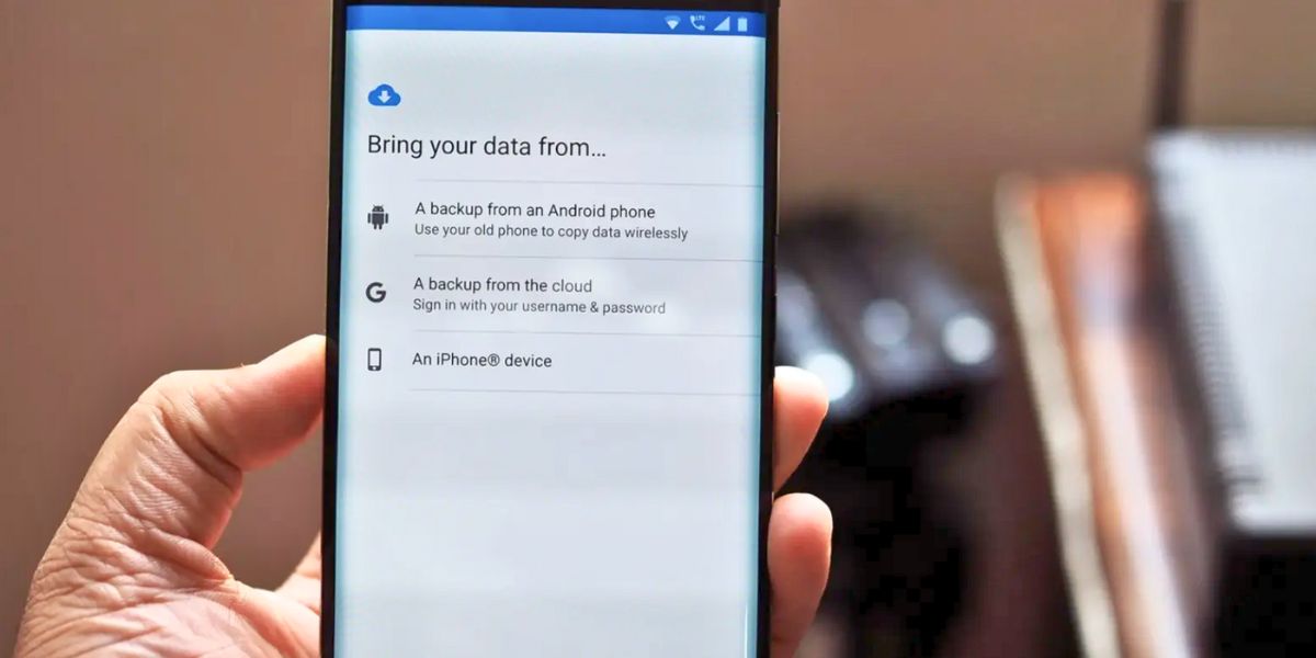 A hand holds a smartphone displaying the data transfer options screen: "Bring your data from